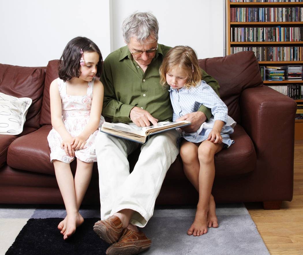 Abuelo leyendo con sus nietas